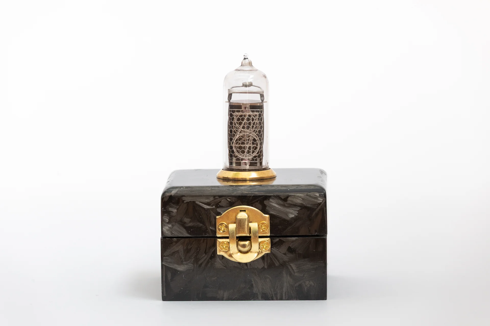 Front view of carbon fiber nixie clock enclosure with brass hardware