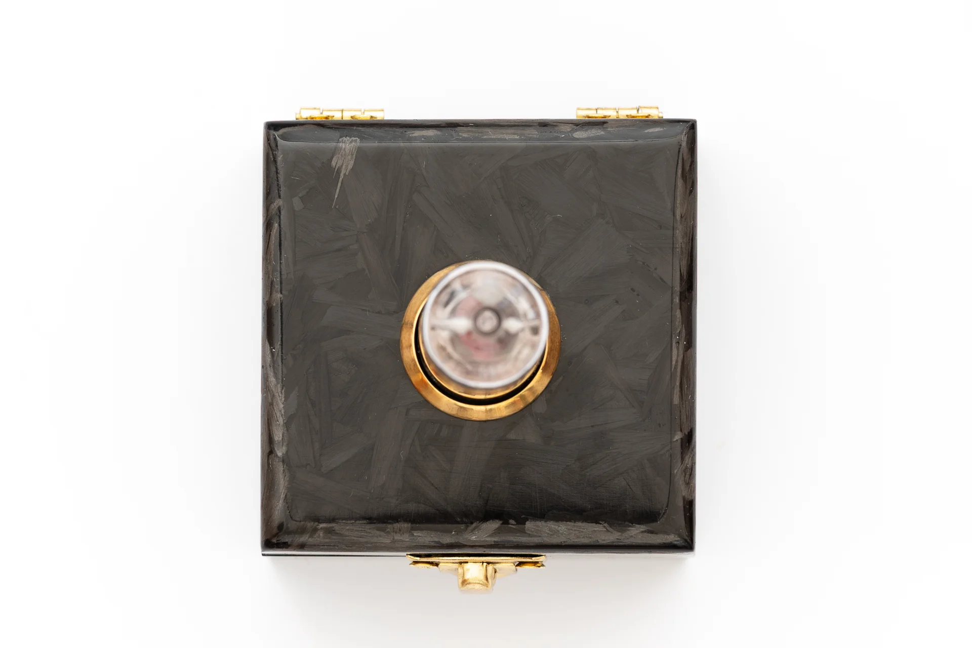 Top view of carbon fiber nixie clock enclosure with brass hardware